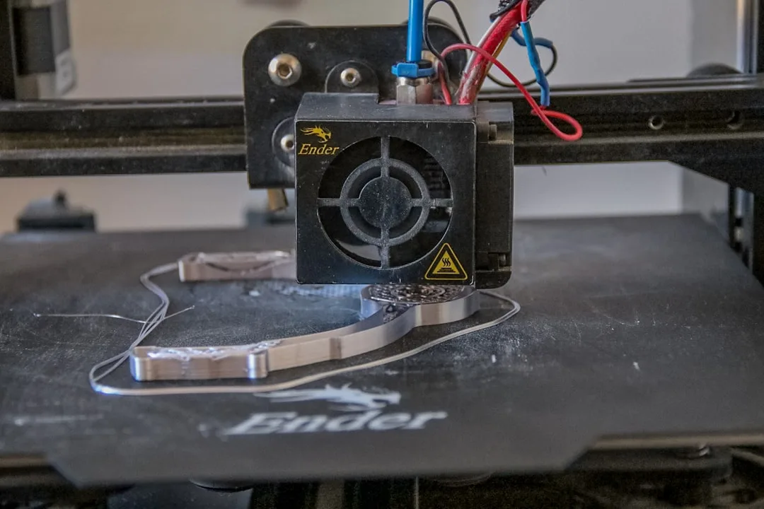 FDM-Drucker mit Düse trägt Filament schichtweise auf ein Bauteil auf