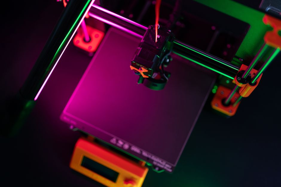 Düse eines FDM-Druckers legt Schicht für Schicht Filament auf ein flach liegendes Bauteil
